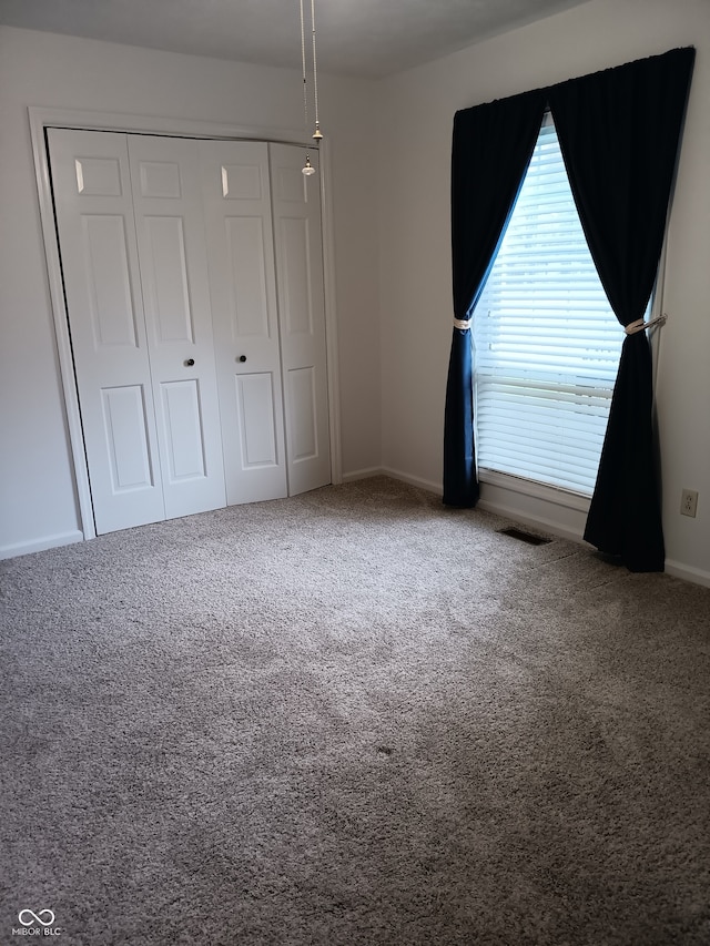 unfurnished bedroom with carpet floors and a closet