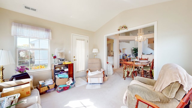 sitting room featuring a notable chandelier, lofted ceiling, and carpet floors