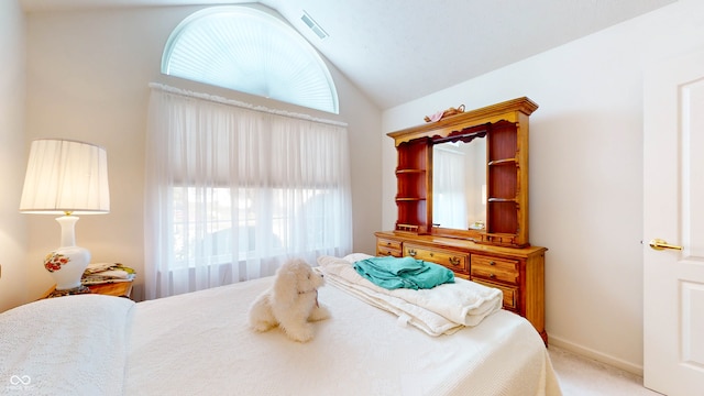 bedroom featuring vaulted ceiling, light carpet, and multiple windows