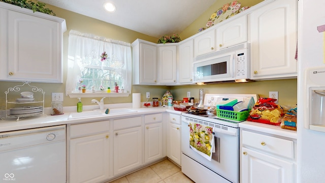 kitchen featuring white cabinetry, sink, light tile patterned floors, and white appliances