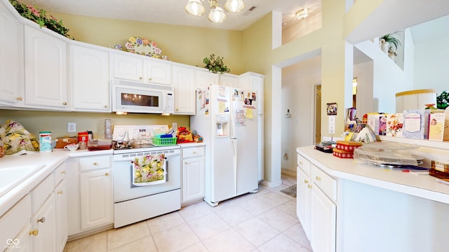 kitchen with white appliances, light tile patterned floors, white cabinetry, and lofted ceiling