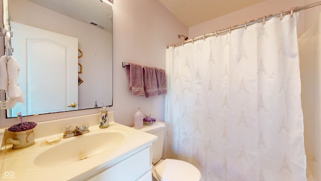 bathroom featuring toilet, vanity, and a shower with shower curtain