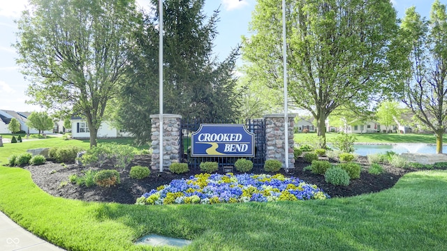 community sign with a yard and a water view