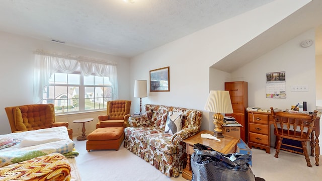 living room with lofted ceiling, a textured ceiling, and carpet floors