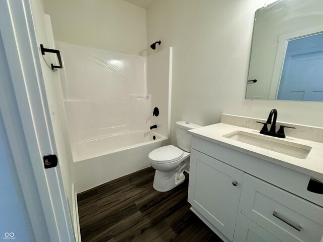 bathroom featuring vanity, toilet, wood finished floors, and bathtub / shower combination