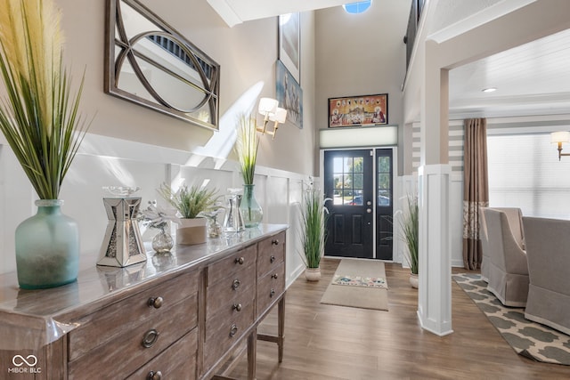 entrance foyer with hardwood / wood-style floors and crown molding