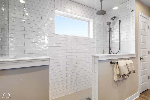 bathroom with wood-type flooring and tiled shower