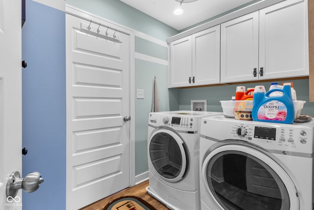 washroom with hardwood / wood-style floors, independent washer and dryer, and cabinets