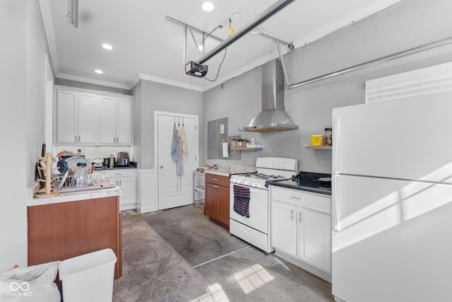 kitchen featuring white appliances, white cabinetry, and wall chimney range hood