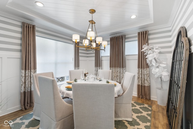 dining room featuring hardwood / wood-style floors, a notable chandelier, and a tray ceiling