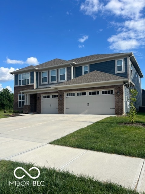 prairie-style home with a garage, a front yard, brick siding, and driveway