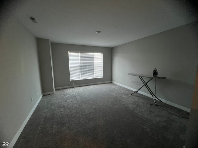 spare room with dark colored carpet