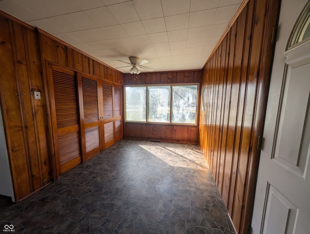 unfurnished sunroom with ceiling fan