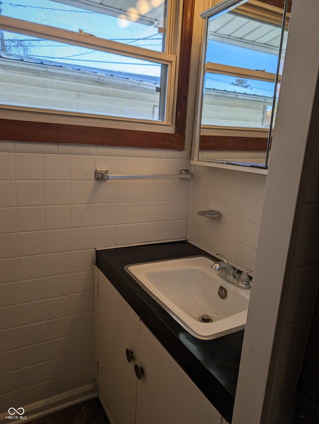 bathroom featuring tile walls, vanity, and a healthy amount of sunlight