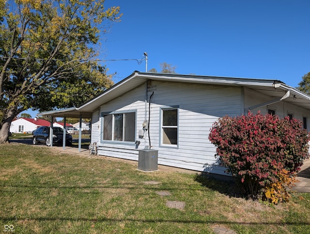 view of home's exterior with a yard, a carport, and central AC unit