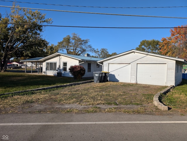 view of front of home featuring a carport, a front lawn, and a garage