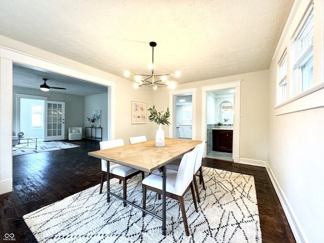 dining space with a textured ceiling, ceiling fan with notable chandelier, and dark hardwood / wood-style flooring