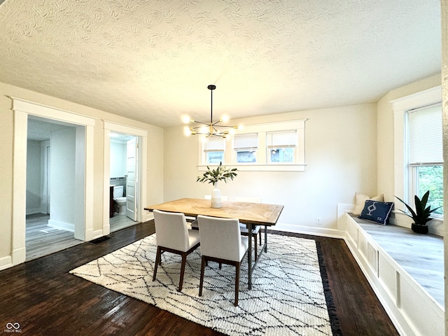 dining room with a notable chandelier, dark hardwood / wood-style floors, and a textured ceiling