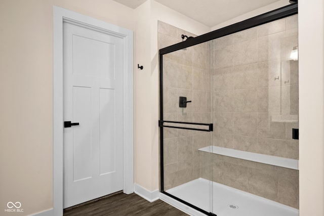 bathroom with hardwood / wood-style flooring and a shower with door