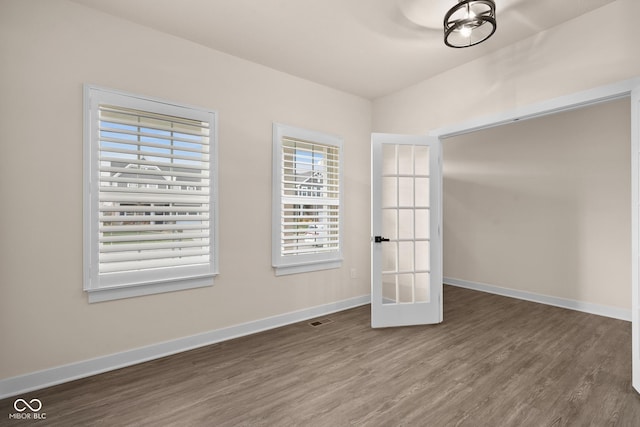 empty room featuring french doors and dark wood-type flooring