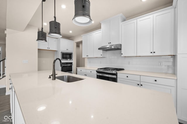 kitchen featuring sink, hanging light fixtures, stainless steel appliances, decorative backsplash, and white cabinets