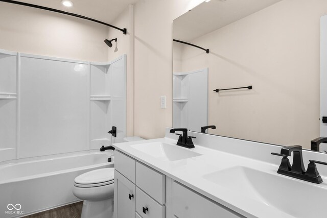 full bathroom featuring washtub / shower combination, vanity, wood-type flooring, and toilet