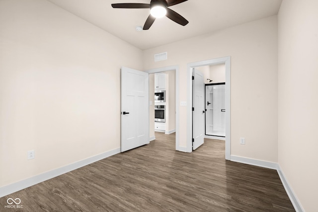 spare room featuring ceiling fan and dark wood-type flooring