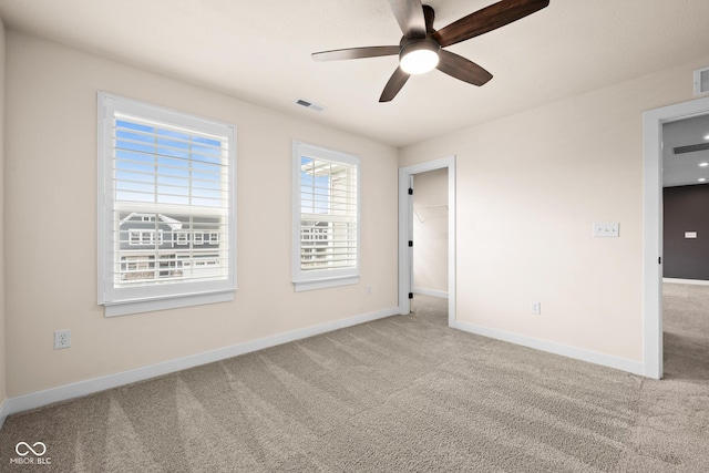 carpeted spare room featuring ceiling fan