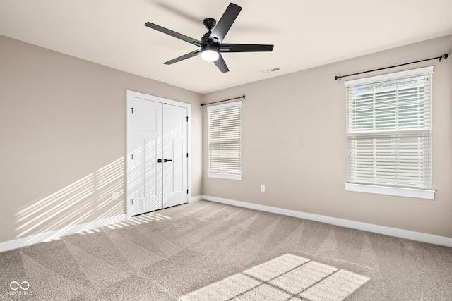 unfurnished bedroom with carpet flooring, ceiling fan, and a closet