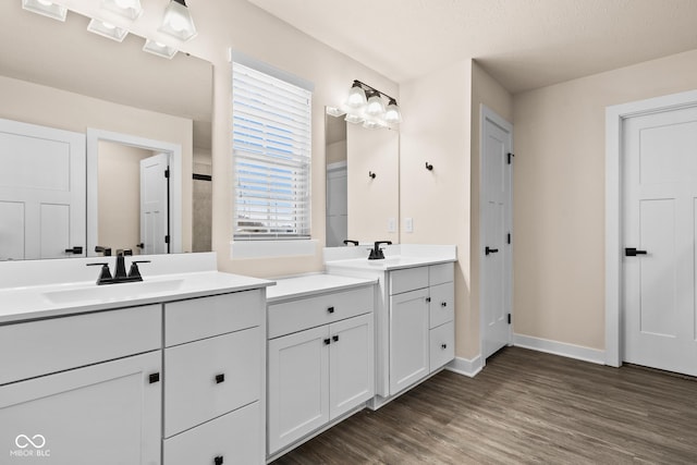 bathroom with wood-type flooring, vanity, and a textured ceiling