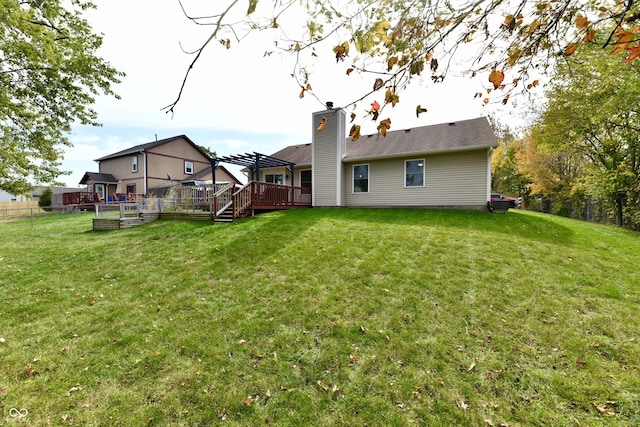 rear view of house with a yard and a deck