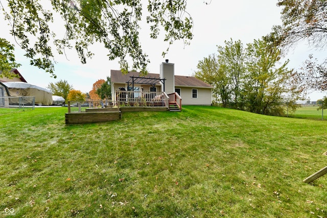 rear view of property featuring a yard and a deck