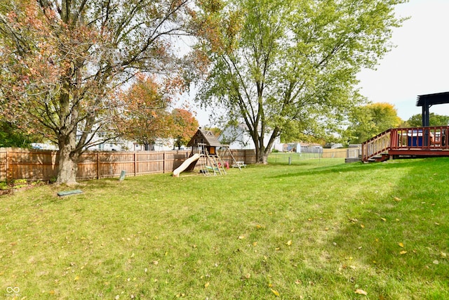 view of yard with a deck and a playground