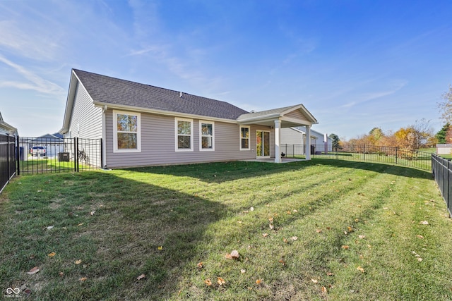 back of property with a lawn and a patio