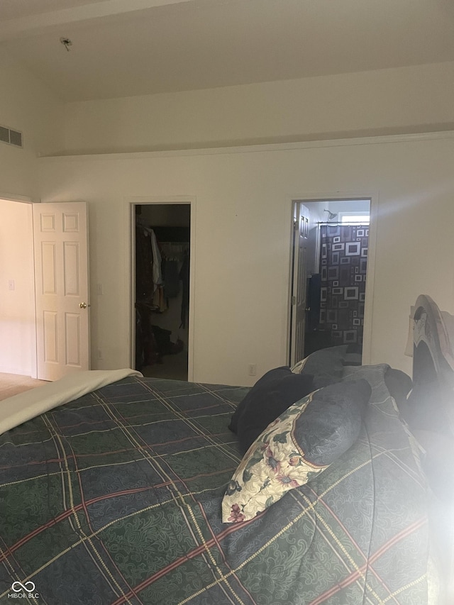 unfurnished bedroom featuring a walk in closet, ensuite bathroom, and a closet