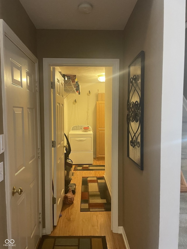 hall with light wood-type flooring and washer / clothes dryer