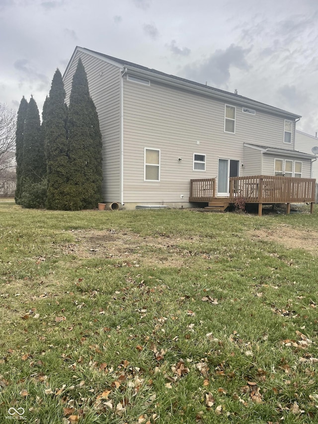 rear view of house featuring a lawn and a deck