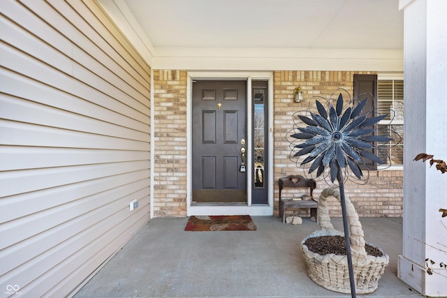 property entrance featuring brick siding