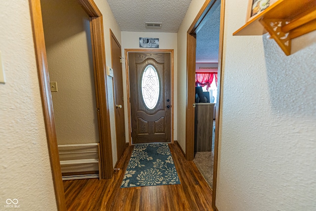 entryway with a textured ceiling and dark hardwood / wood-style floors