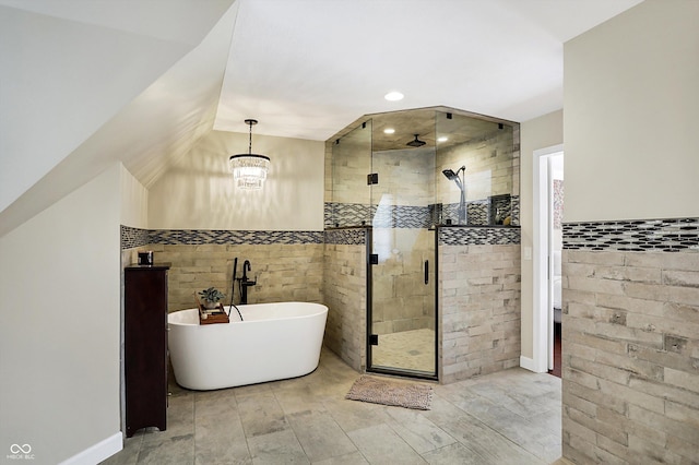 bathroom featuring tile walls, vaulted ceiling, independent shower and bath, and a chandelier