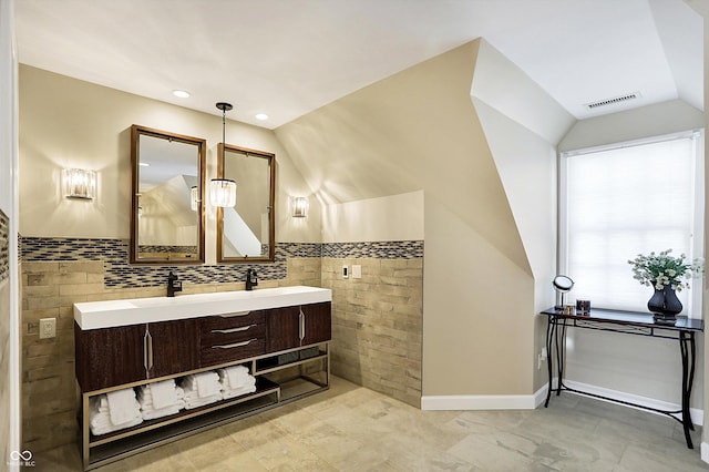 bathroom with vaulted ceiling, tile walls, and vanity