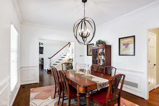 dining space with crown molding, dark hardwood / wood-style floors, and a chandelier