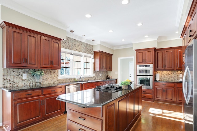 kitchen featuring light hardwood / wood-style flooring, hanging light fixtures, stainless steel appliances, a center island, and dark stone counters