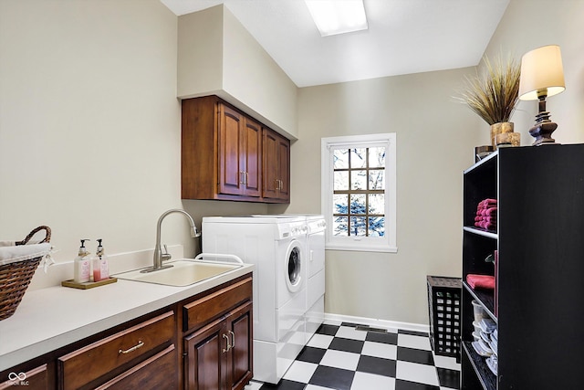 laundry room with cabinets, washer and clothes dryer, and sink