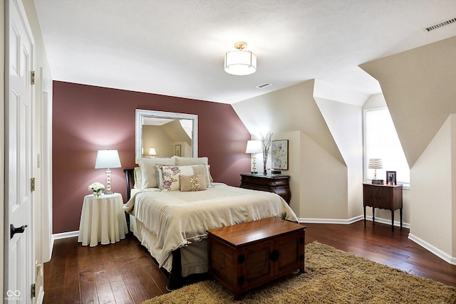 bedroom with vaulted ceiling and dark wood-type flooring