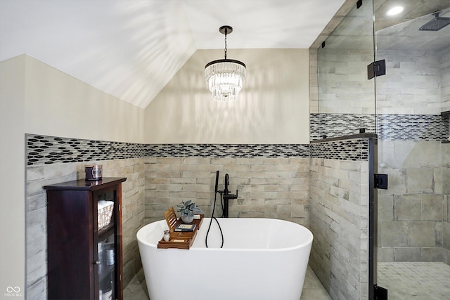 bathroom featuring independent shower and bath, vaulted ceiling, and a notable chandelier