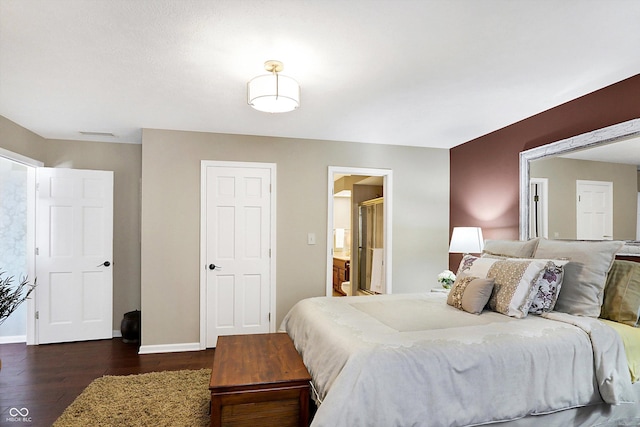 bedroom featuring ensuite bathroom and dark hardwood / wood-style floors