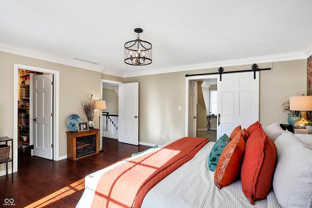 bedroom featuring crown molding, a barn door, dark hardwood / wood-style floors, and a chandelier