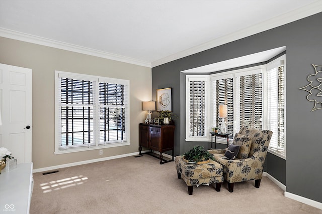 sitting room with ornamental molding and light colored carpet