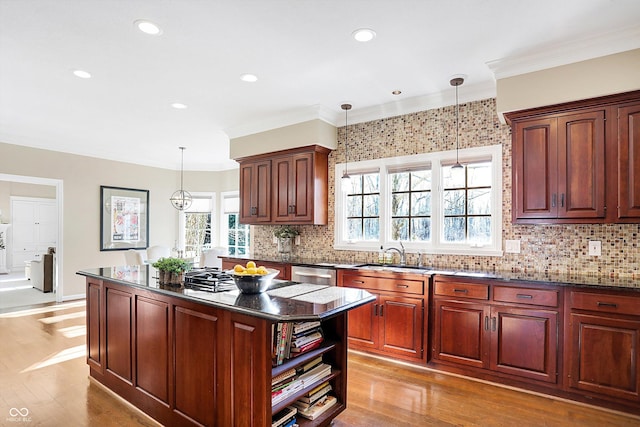 kitchen featuring sink, decorative light fixtures, a center island, ornamental molding, and dishwasher